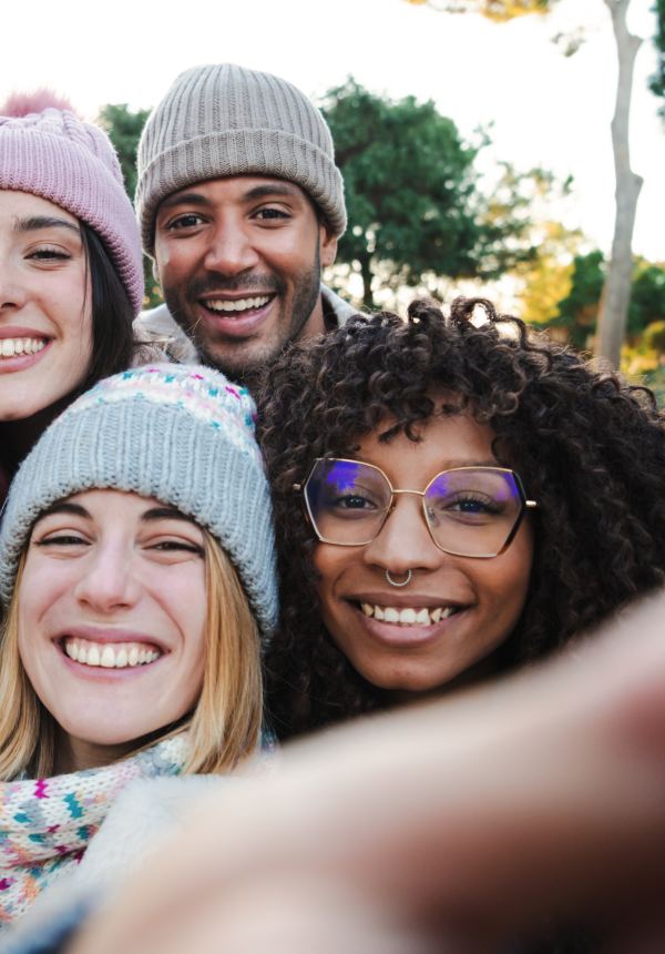 Amis en bonnets qui sourient pour un selfie d'hiver