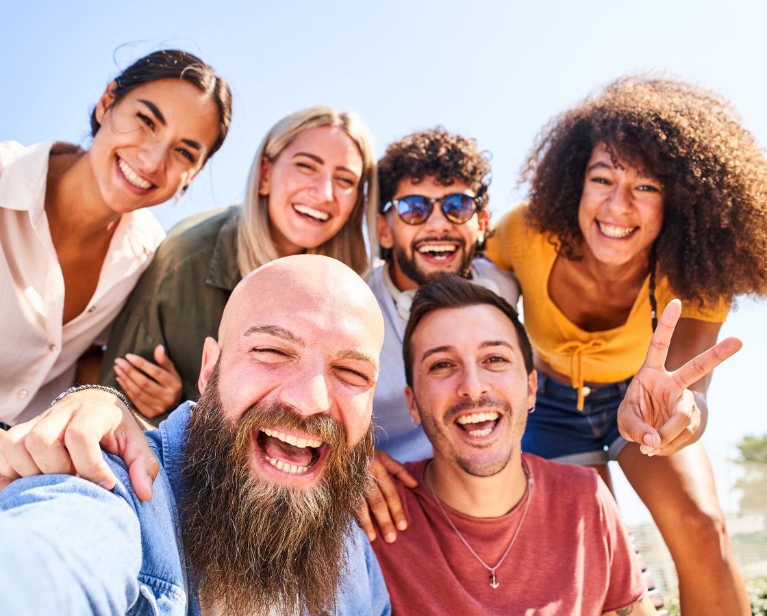 Bande d'amis souriants qui prennent un selfie au soleil